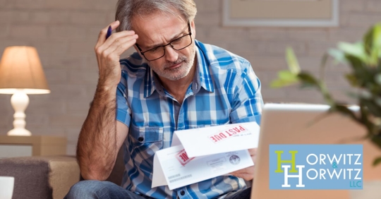 man looking over past due bills